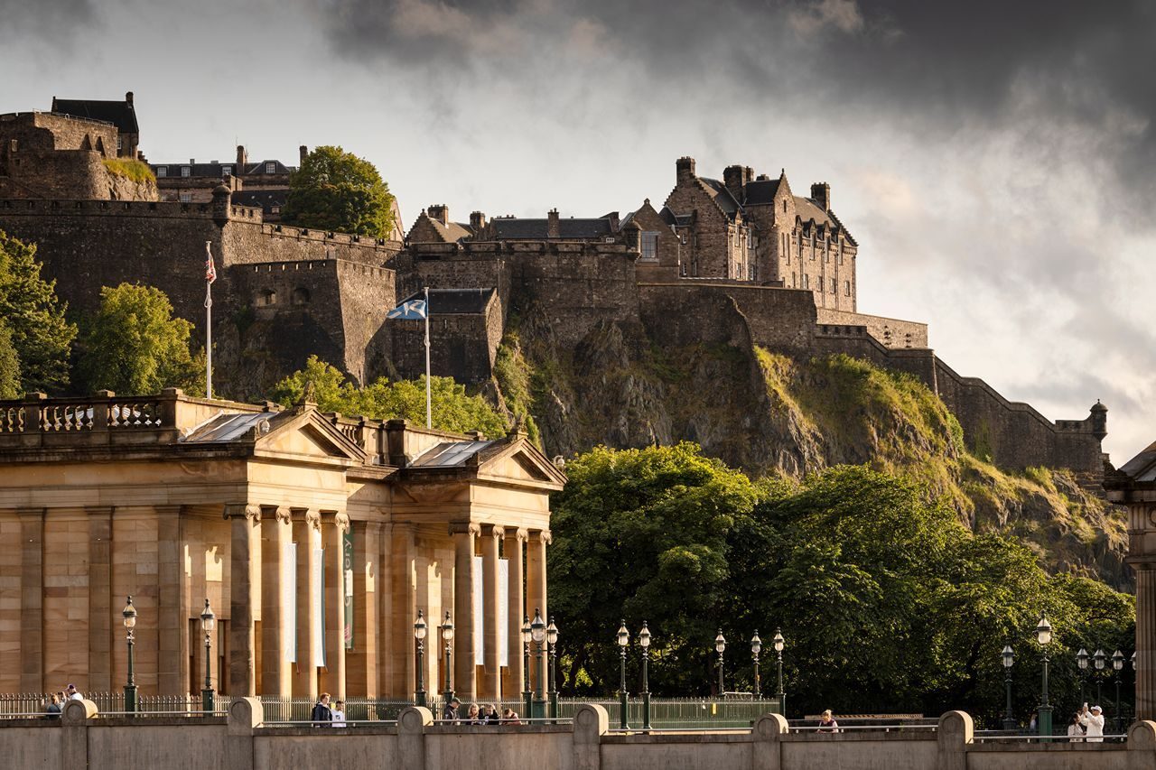 A panoramic view of Edinburgh Castle, highlighting its stone walls and towers atop a rocky outcrop in Scotland.