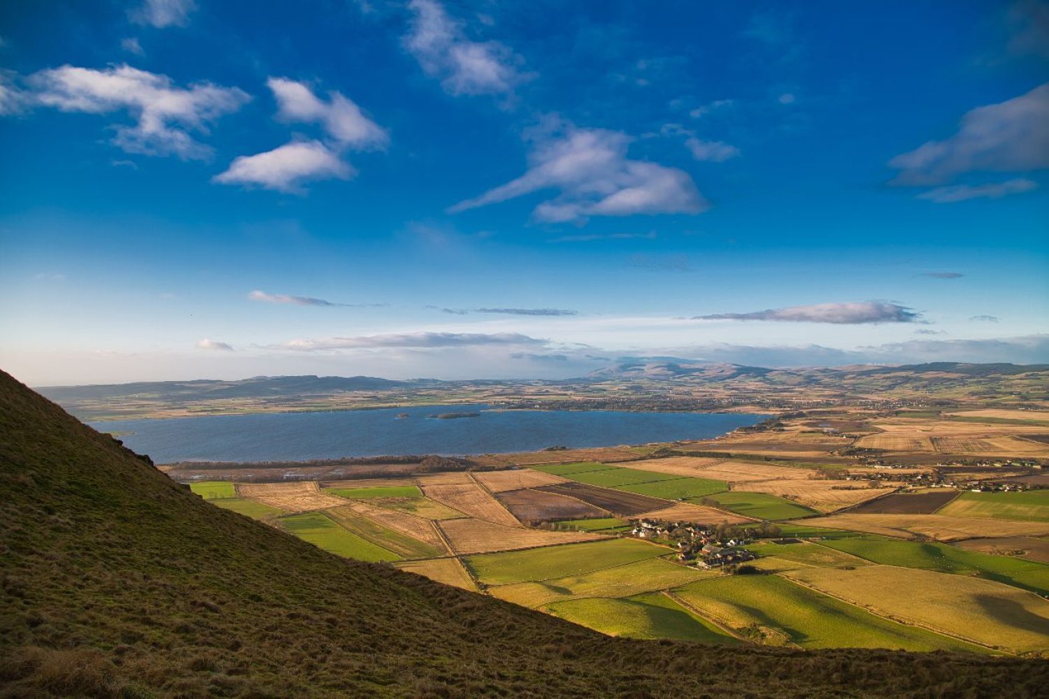 The view towards Loch Leven overlooking fields from a hilltop