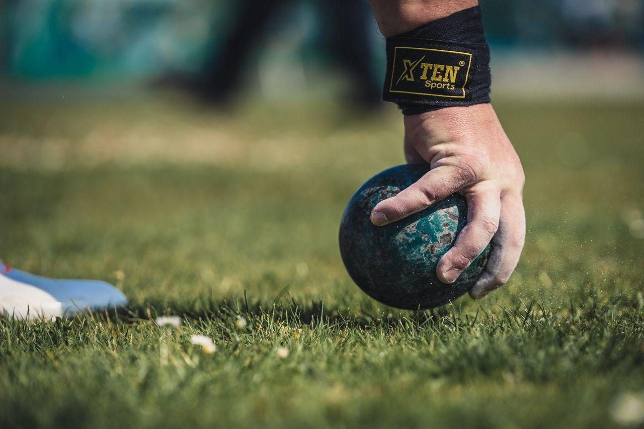 A male hand grabbing a shot putt