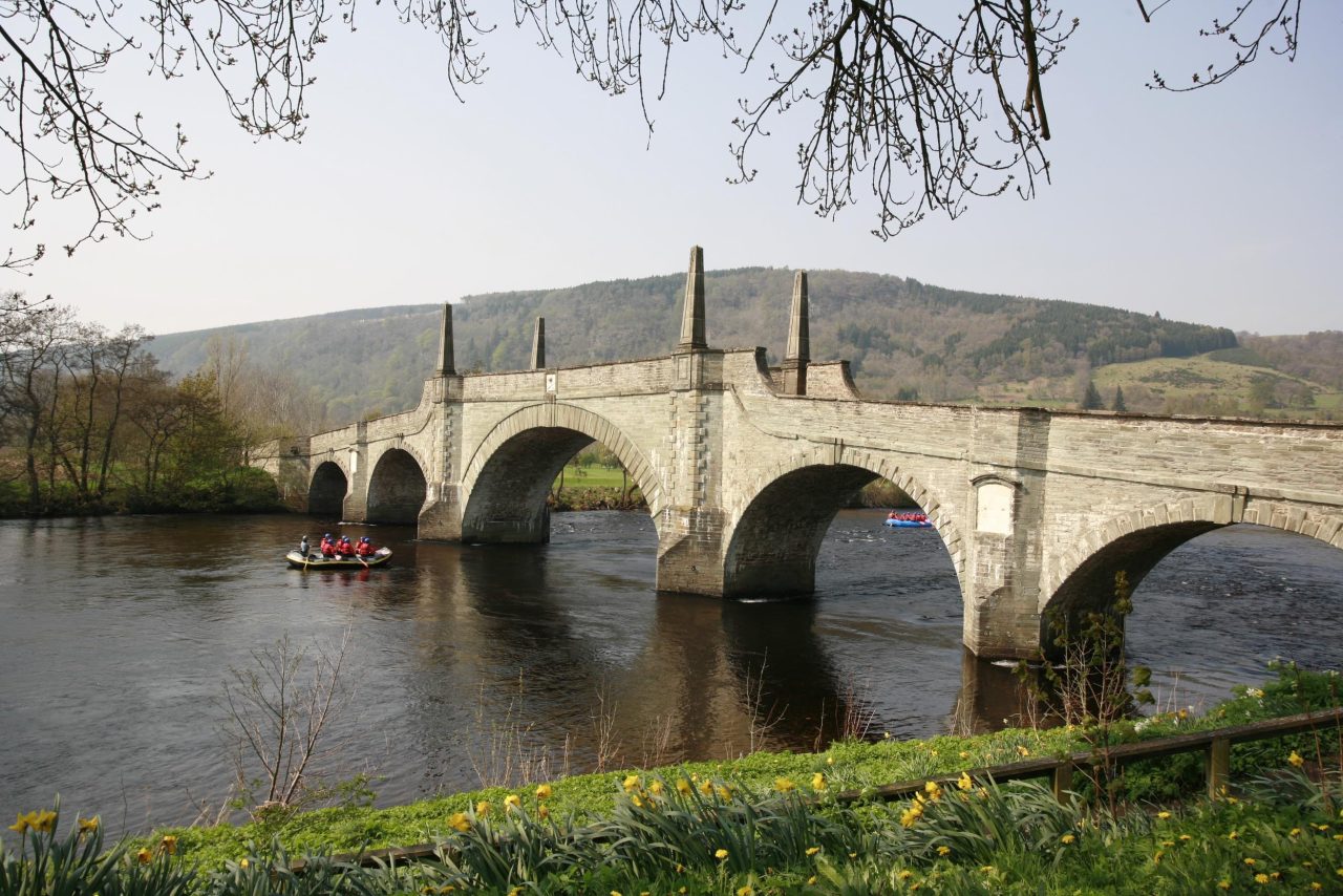 An arching stone bridge spanning over a river