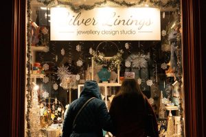 A beautiful Christmas shopping window with two women looking in.