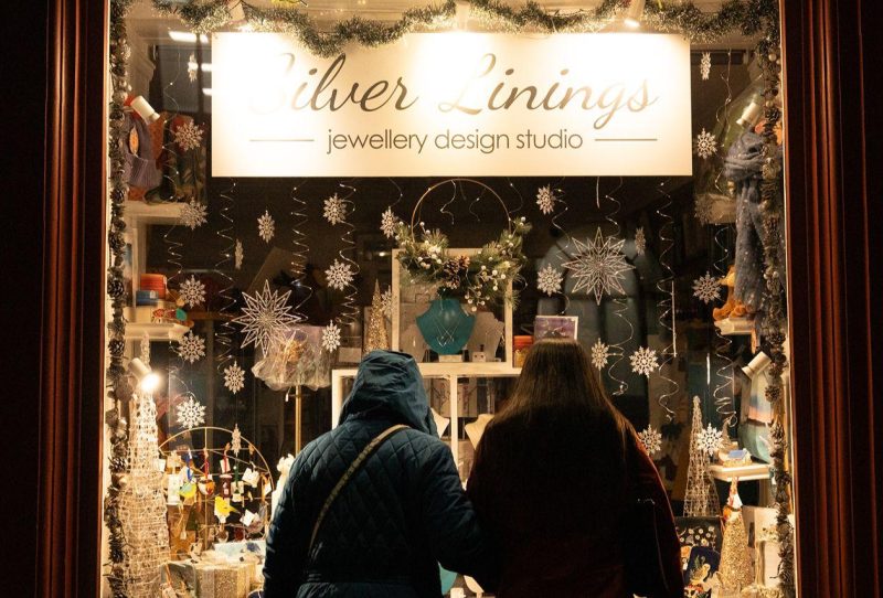 A beautiful Christmas shopping window with two women looking in.