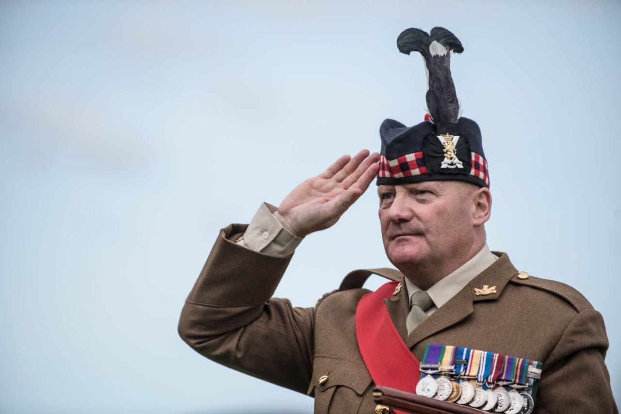 A man wearing military uniform saluting.