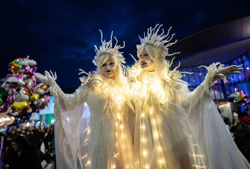two street entertainment women in magical white floating gowns with crowns