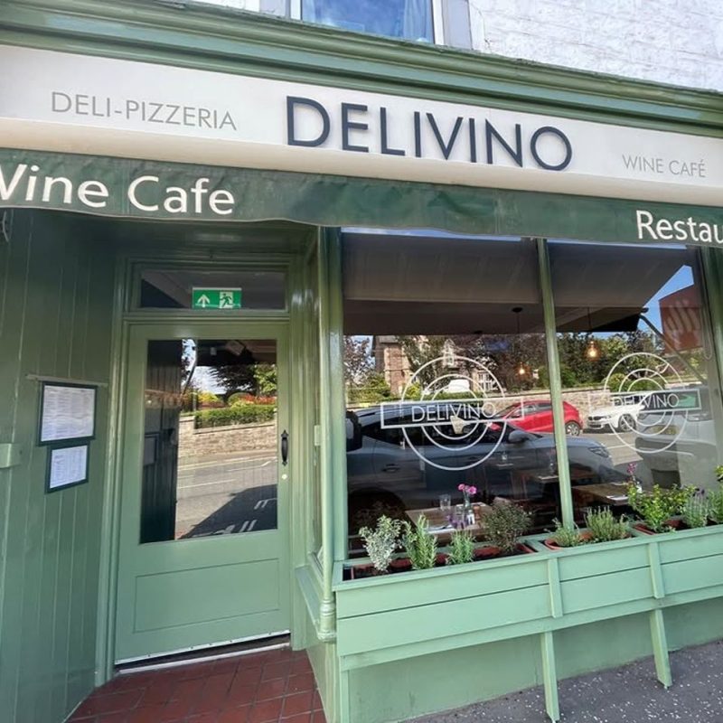 Green painted restaurant front with cream , signage says Delivinio. wine cafe. deli. pizzeria