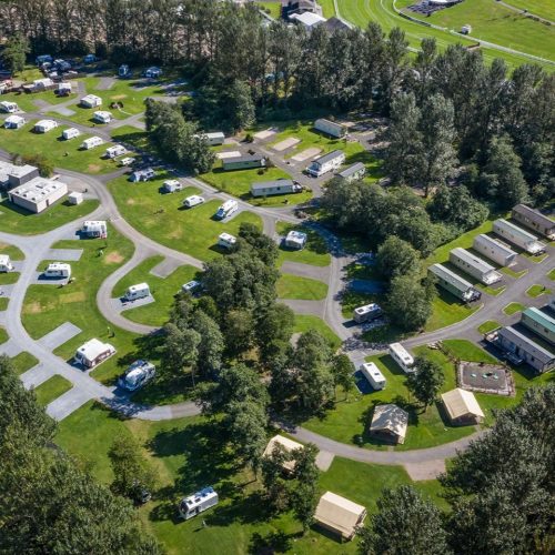 Road with bases for caravans surround by trees on a sunny day