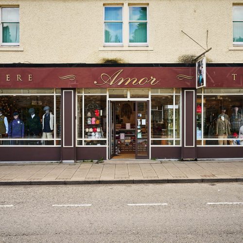 A burgundy storefront with gold text which reads 'Amor'.