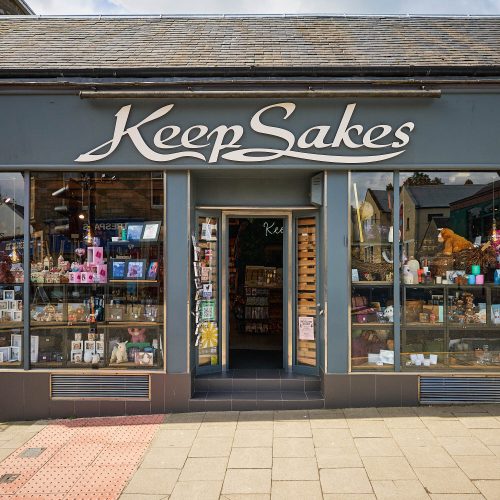 A grey building with a white sign which reads 'Keep Sakes.'