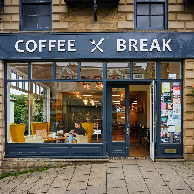 A dark blue coffee shop with a white sign which reads 'Coffee Break'.