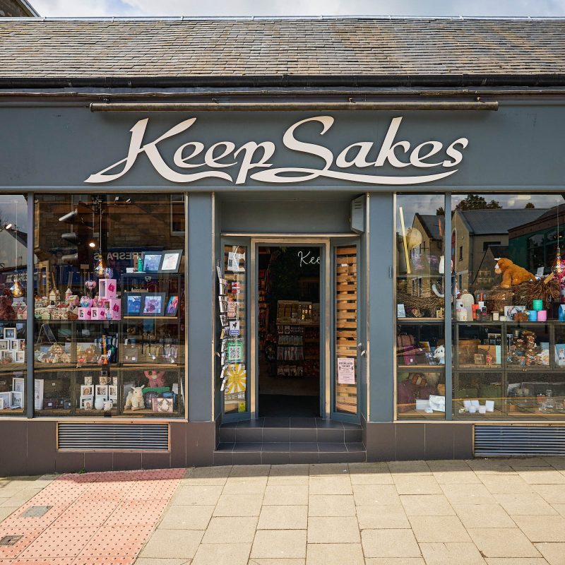 A grey building with a white sign which reads 'Keep Sakes.'