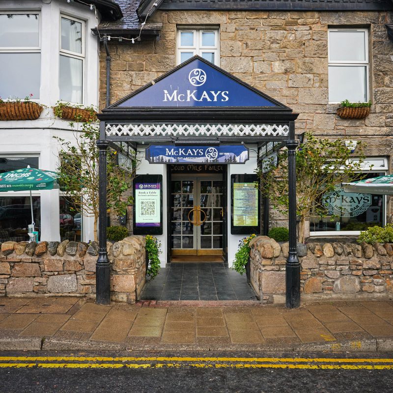 A brick building with a dark blue sign which says McKays on it.