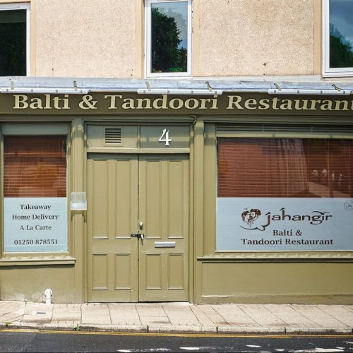Jahangir Balti Tandoori restaurant with two beige doors in the middle and two large windows either side